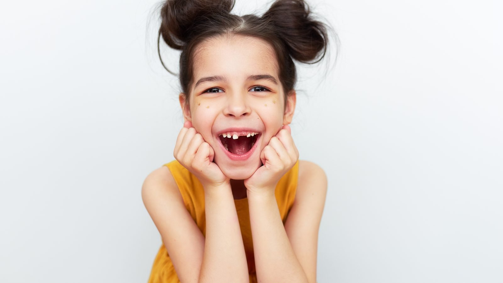 A young patient with a playful, gap-toothed smile