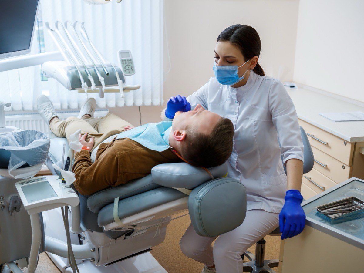A dental surgical operatory in use — a clinician working chairside in a fully equipped treatment room, representative of the dedicated surgical suite at Stouffville Dental Studio