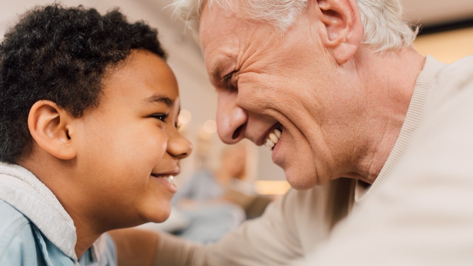 An older man and his young grandson laughing together